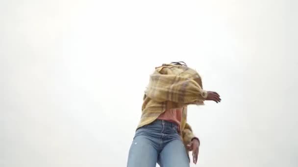 Χαμηλή γωνία της αφρικανικής αμερικανικής θηλυκό κουνώντας το κεφάλι, ενώ χορεύουν στην άκρη του τσιμεντένιου δρόμου - Πλάνα, βίντεο