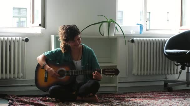 mladá žena hraje s kytarou v místnosti - Záběry, video