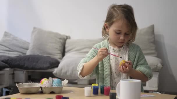Frohe Osterfeiertage. Schöne kleine Mädchen malen und dekorieren Osterei - Filmmaterial, Video