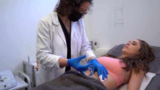 Professzionális kozmetikus, aki a kozmetikai klinikán cellulitisz kezelés alatt injekciót ad be nőknek - Felvétel, videó