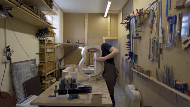 Ενηλίκων male artisan κατασκευή κλασικού μουσικού οργάνου με ξύλινα κομμάτια και σφιγκτήρας στο εργαστήριο - Πλάνα, βίντεο