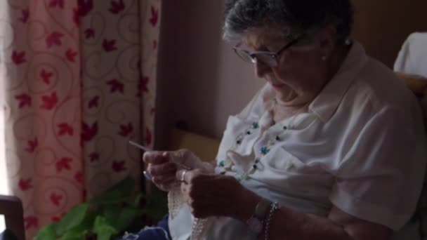 Aufnahmen einer älteren Frau, die allein zu Hause strickt - Filmmaterial, Video