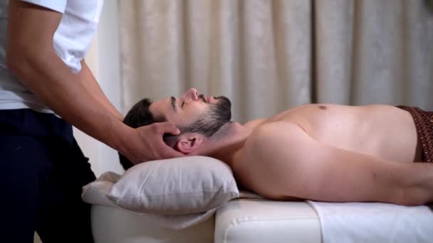 молодой человек, принимающий азиатский массаж в спа-салоне - Кадры, видео