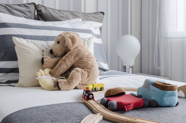 Dormitorio de niño con muñecas y juguetes en la cama
 - Foto, imagen