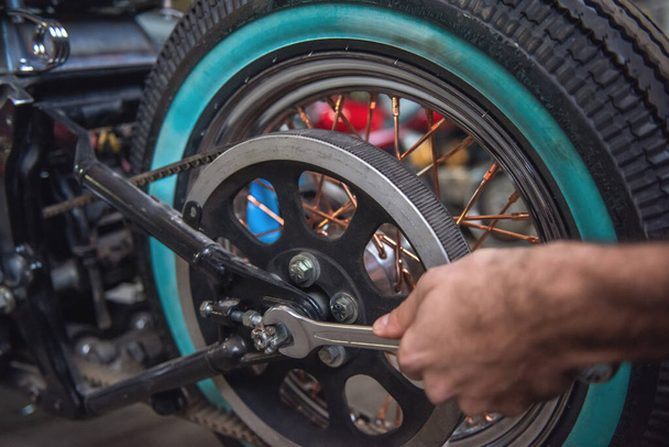 Immagine ritagliata dell'uomo che ripara una moto in officina
 - Foto, immagini