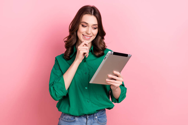 Photo of thoughtful pretty lady wear green shirt typing email modern gadget hand arm chin isolated pink color background. - Фото, изображение