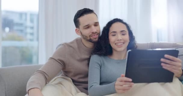 Tablet, couple talk and home with tech and film streaming with love and care on sofa. Living room, website and watching movie online with young people together in lounge with social media app scroll. - Footage, Video