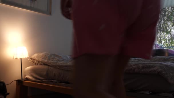 Mujer de mediana edad, en pijama, camiseta, rubia de pelo largo, acostada, apagando la luz - Metraje, vídeo