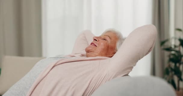 Gülümse, rahatla ve huzur için evdeki kanepede uzanan yaşlı kadın. Huzurlu, sakin ve yaşlı bir insan. Rahatlamış, özgür ve stressiz. Evdeki kanepede nefes alıyor ve rahatlıyor. - Video, Çekim