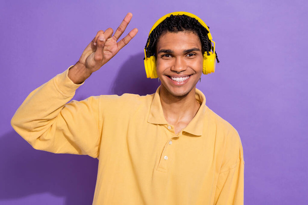 Фото фанки удовлетворенного позитивного человека с кукурузными рожками носить стильную руку рубашки с V-знак символ изолирован на фиолетовом фоне цвета. - Фото, изображение