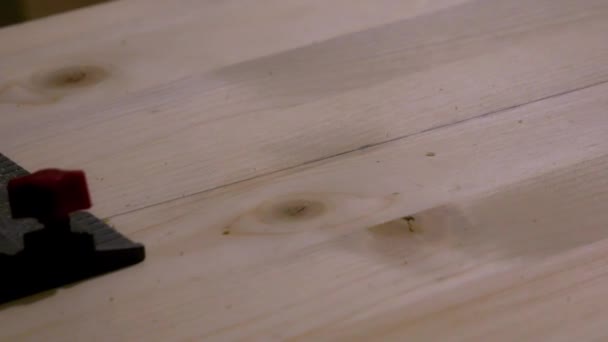 zbliżenie piły tarczowej tnącej drewnianą deskę do prac budowlanych - Materiał filmowy, wideo