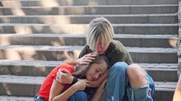 Rozrušená dívka pláče ležící na klíně svých přátel. Přátelská podpora dospívajícího přítele. - Záběry, video