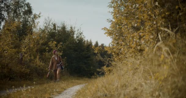 Νεαρή γυναίκα εξερευνητής κοιτάζοντας γύρω ενώ η εξερεύνηση από τα δέντρα στο δάσος κατά τη διάρκεια των διακοπών - Πλάνα, βίντεο