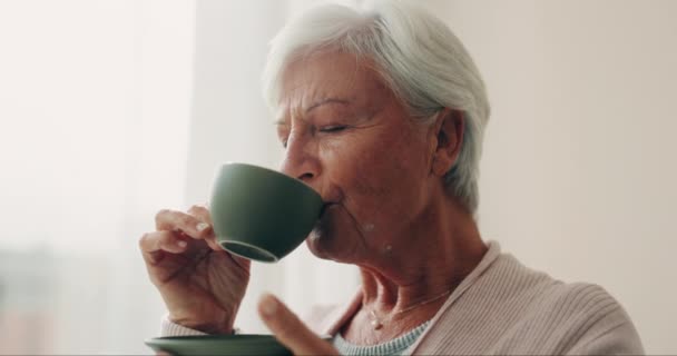Klid, čaj a starší žena pijící z poháru v obývacím pokoji svého domova důchodců. Tvář, úsměv nebo mír a postarší důchodkyně, která se cítí bezstarostně s nápojem. - Záběry, video