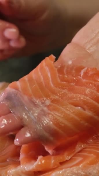 con coltello affilato tagliare grandi pezzi di pesce rosso salmone salato cottura per sushi a casa video al rallentatore - Filmati, video
