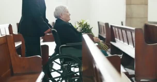 Śmierć, pogrzeb i kościół ze starą kobietą i użytkownikiem wózków inwalidzkich dla smutnych, opłakiwania i wdowy. Depresja, żal i pomoc z osobą niepełnosprawną w kaplicy w związku z żałobą, pogrzebem i stratą. - Materiał filmowy, wideo