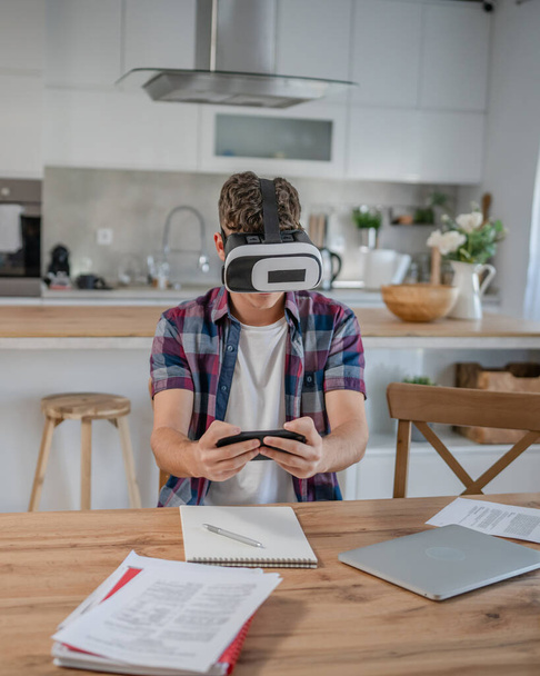 юноша кавказский подросток студент наслаждается виртуальной реальностью VR гарнитура дома, пока принять тормоз - Фото, изображение