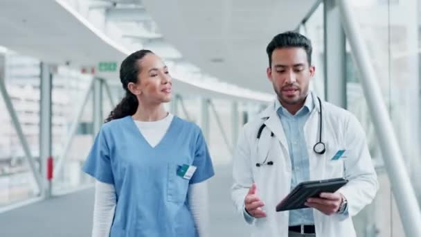 People, doctor and tablet walking in healthcare, discussion or planning together at the hospital. Man and woman medical professional with technology for health service, results or teamwork at clinic. - Footage, Video