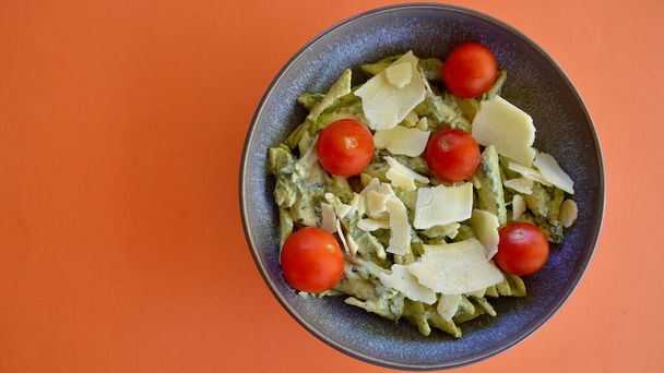 Tıraşlı parmesan peyniri ve kiraz domatesli fesleğen soslu makarna salatası. - Fotoğraf, Görsel