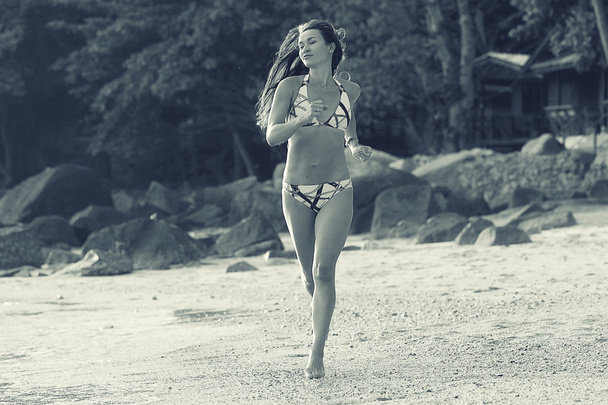 Beautiful girl running on beach - 写真・画像