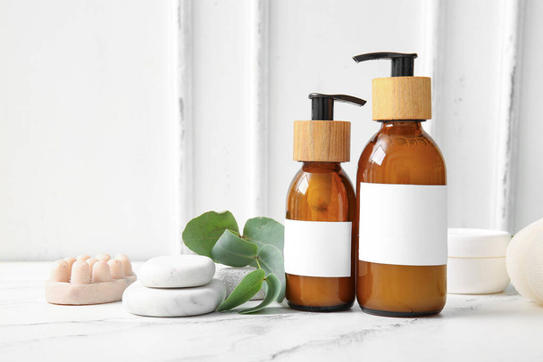Flaschen Shampoo, Seifenblase und Wellness-Steine auf dem Tisch - Foto, Bild