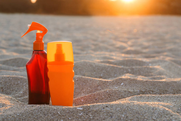 Пляшки сонцезахисного крему на піску на пляжі - Фото, зображення