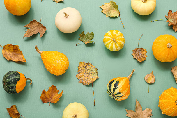 Herbstkomposition mit Kürbissen und Blättern auf grünem Hintergrund - Foto, Bild