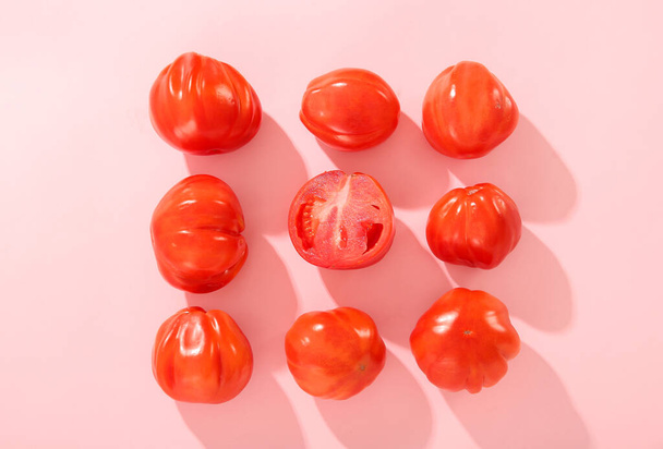 Свежие спелые помидоры на розовом фоне - Фото, изображение