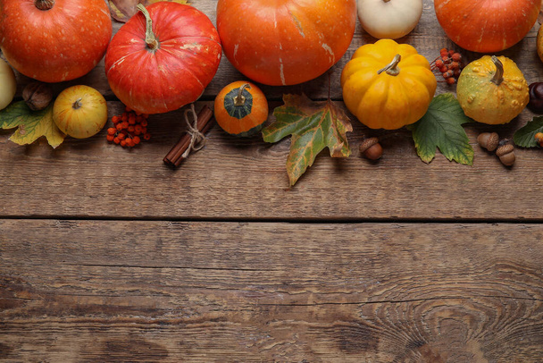 Composition with pumpkins and autumn leaves on brown wooden background - Photo, Image