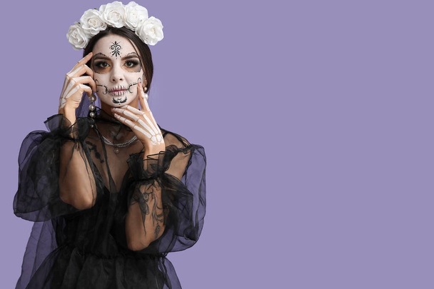 Piękna młoda kobieta przebrana za martwą pannę młodą na Halloween party na fioletowym tle - Zdjęcie, obraz