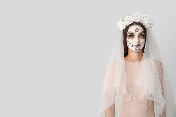 美しい若い女性は灰色の背景でハロウィーンのパーティーのための死んだ花嫁として服を着た - 写真・画像