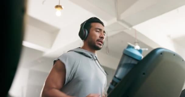 Fitness, Uhr und Mann auf einem Laufband mit Kopfhörern beim Gymnastiktraining. Profil des asiatischen Athleten Person, die Musik zum Laufen, Cardio-Zeit oder Workout auf dem Gerät für die Gesundheit hört. - Filmmaterial, Video