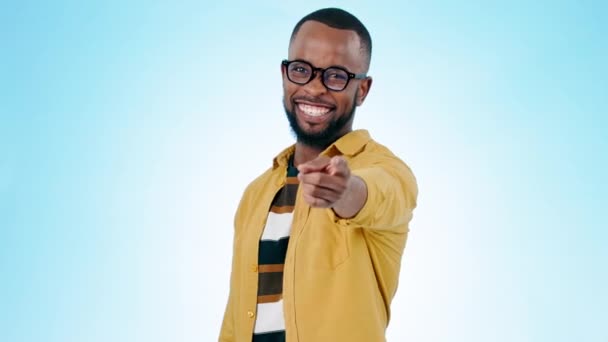 Pointing, you and face of black man on blue background for promotion, encouragement and choosing. Emoji, happy and portrait of person with hand gesture for show, agreement and decision in studio. - Footage, Video