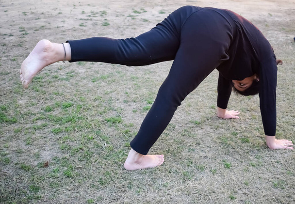 Young Indian woman practicing yoga outdoor in a park. Beautiful girl practice basic yoga pose. Calmness and relax, female happiness. Basic Yoga poses outdoor - Valokuva, kuva