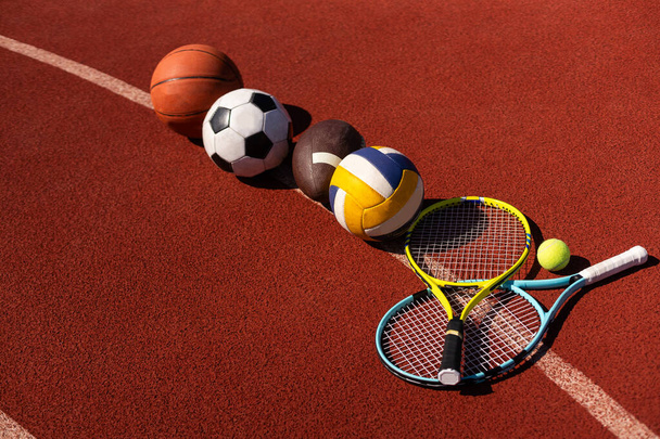 Zestaw sprzętu sportowego, piłki do koszykówki i rakiety tenisowe. - Zdjęcie, obraz