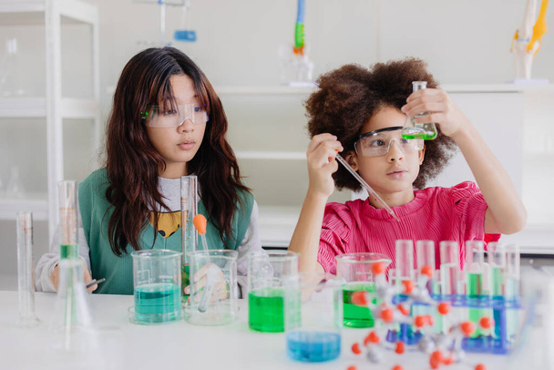 Afro zwarte kid diversiteit kinderen spelen in de wetenschap chemisch lab voor het leren van onderwijs op school met een vriend - Foto, afbeelding
