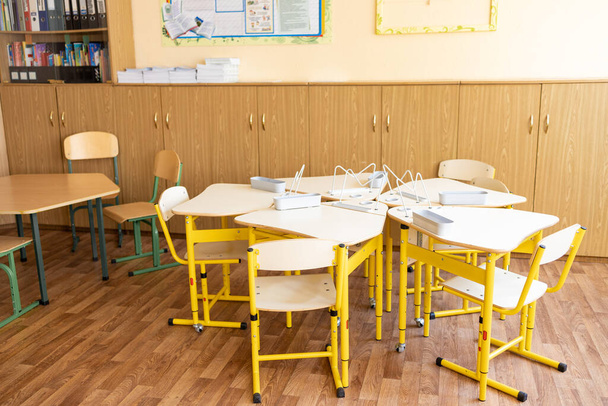 Пустой современный класс со стульями, столами и доской. - Фото, изображение