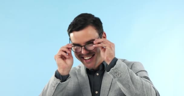 Oogverzorging, portret en vrolijke man met bril voor zicht, focus en frames in studio op blauwe achtergrond. Zakenman, gezicht en geluk met overleg bij optometrist voor brillen of brillen. - Video
