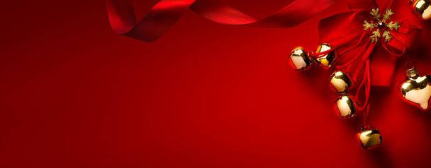 Χριστουγεννιάτικη ευχετήρια κάρτα ή σχέδιο πανό διακοπές? Χρυσή διακόσμηση χριστουγεννιάτικο δέντρο και μεταξωτή κορδέλα σε κόκκινο φόντο? Αντιγραφή χώρου - Φωτογραφία, εικόνα
