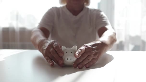 Mulher com banco de moedas porquinho, orçamento doméstico, finanças e conceito de poupança. Imagens FullHD de alta qualidade - Filmagem, Vídeo