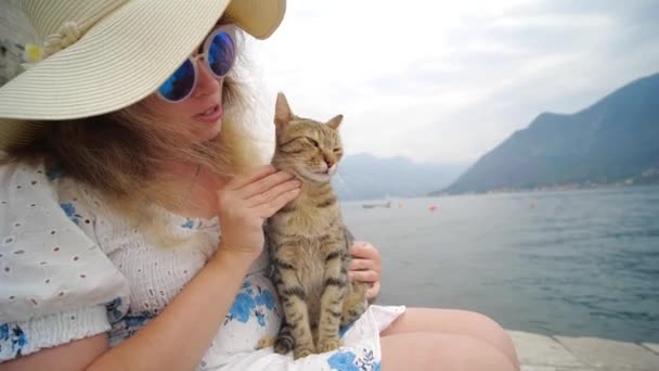 kobieta odpoczywa na świeżym powietrzu w przyrodzie i bawić się z kotem - Materiał filmowy, wideo