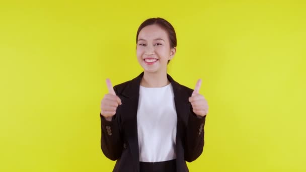 Portrét mladé asijské obchodní žena prezentovat a palce nahoru izolované na žlutém pozadí, reklama a marketing, výkonný a manažer, podnikatelka sebejistý představení s výrazem. - Záběry, video