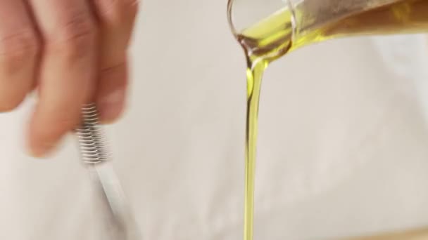 Olie wordt toegevoegd aan vinaigrette - Video