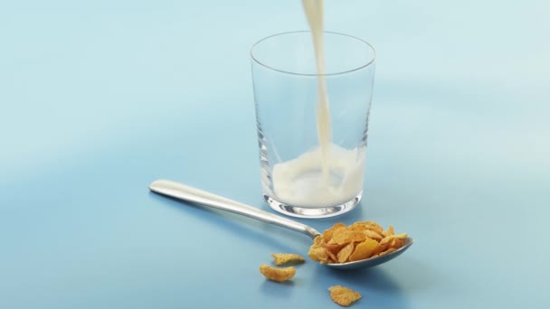 Lžíce kukuřičné lupínky a sklenice mléka - Záběry, video