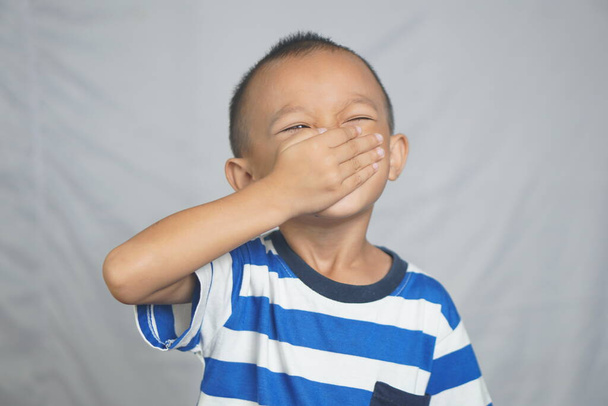 Un niño se cubre la nariz con la mano para evitar el mal olor. - Foto, imagen