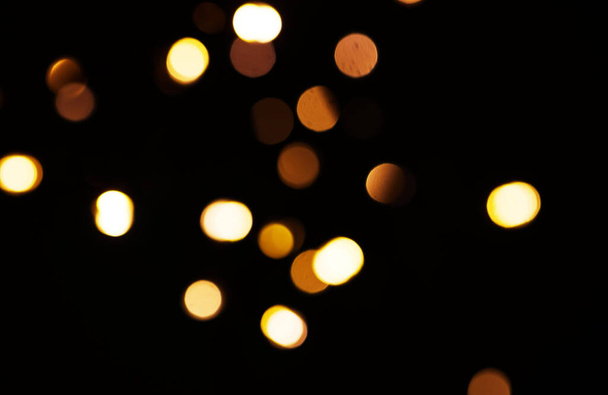 Oro, luz y maqueta con bokeh sobre fondo oscuro para la celebración de Año Nuevo, Navidad o fuegos artificiales festivos por la noche. Burla, espacio o destello en invierno con magia, brillo o brillo sobre fondo negro. - Foto, imagen