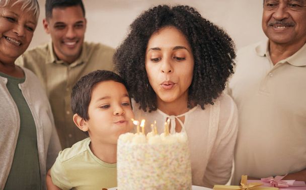 Joyeux anniversaire, grande famille et enfant avec gâteau soufflant bougie dans une maison pour l'événement à célébrer ensemble dans une maison. Grand-parents, bonheur et enfant excités pour la collecte, surprise et cadeau. - Photo, image