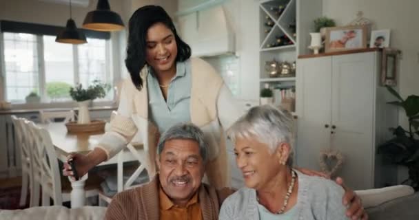 Selfie, sala de estar y mujer con padres mayores unidos en un sofá para relajarse en casa. Feliz, sonrisa y persona femenina tomando una foto con ancianos jubilados en el salón - Imágenes, Vídeo