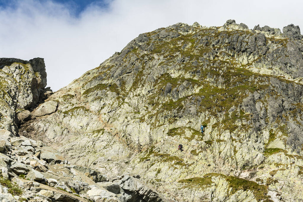 Ein Tourist auf dem Weg und der andere auf dem nahe gelegenen Klettersteig nach Priecne sedlo (Czerwona Lawka) in der slowakischen Hohen Tatra. - Foto, Bild