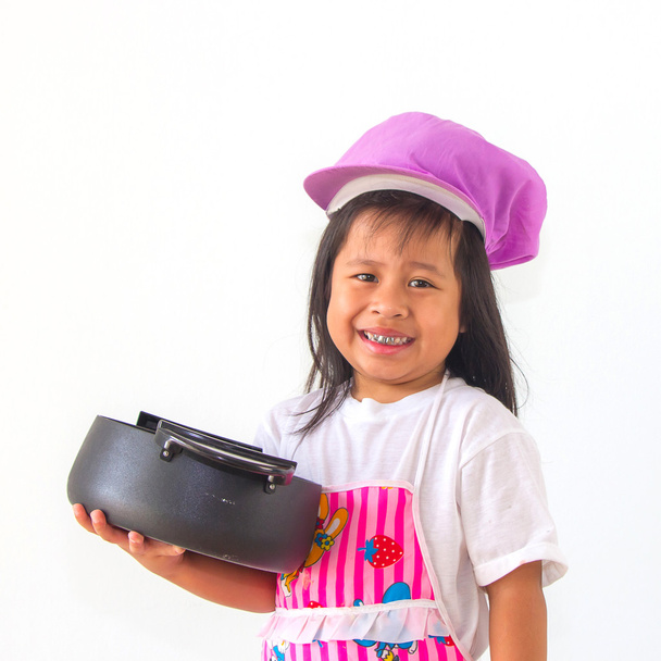 маленькая девочка повар держа горшок на белом фоне
. - Фото, изображение